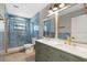 Stylish bathroom featuring double sinks, blue tile accent wall and modern gold fixtures at 5474 Dominica Cir, Sarasota, FL 34233