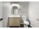 Modern half-bath features stylish fixtures, gold accents, vanity and black/white tiled flooring at 5474 Dominica Cir, Sarasota, FL 34233