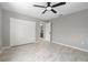 Neutral bedroom with tile floors, ceiling fan, closet and a doorway with a view of the bathroom at 5474 Dominica Cir, Sarasota, FL 34233