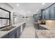 Modern kitchen boasts granite countertops, stainless steel appliances, and stylish blue cabinetry at 5474 Dominica Cir, Sarasota, FL 34233