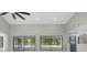 Bright living room featuring vaulted ceilings, recessed lighting, and sliding doors to the outdoor pool area at 5474 Dominica Cir, Sarasota, FL 34233
