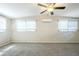 A spacious bedroom with carpet flooring, large windows, and a ceiling fan at 1314 Larsen Ln, Tampa, FL 33619