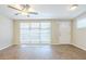 Bright living room with new flooring, large windows, and a ceiling fan at 1314 Larsen Ln, Tampa, FL 33619