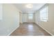Living room featuring hardwood flooring, large windows with blinds, and a white door at 1314 Larsen Ln, Tampa, FL 33619