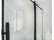 Modern bathroom featuring a glass-enclosed shower with marble tiling and black hardware fixtures at 4925 Alcazar S Way, St Petersburg, FL 33712
