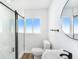 Bathroom featuring a modern shower with glass door and black hardware and a round mirror at 4925 Alcazar S Way, St Petersburg, FL 33712