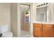 Bathroom featuring a glass-enclosed shower, wood cabinets, and a large mirror at 12219 Hunters Lake Dr, New Port Richey, FL 34654