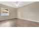 Cozy bedroom with a ceiling fan, wood flooring, and a bright window at 12219 Hunters Lake Dr, New Port Richey, FL 34654