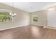 Spacious living room featuring wood flooring, natural light, and a modern chandelier at 12219 Hunters Lake Dr, New Port Richey, FL 34654