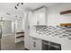 Contemporary kitchen featuring white cabinets, a stainless steel dishwasher, and modern shelving at 1820 Marvy Ave, Tampa, FL 33612