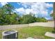 A large, well-maintained backyard with green grass, tall trees and an AC unit at 3504 Kearsney Abbey Cir, Dover, FL 33527