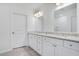 This bathroom features double sinks, granite countertop, a large mirror and white cabinetry at 3504 Kearsney Abbey Cir, Dover, FL 33527