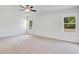 This primary bedroom features carpeted floor, white walls, ceiling fan and large windows at 3504 Kearsney Abbey Cir, Dover, FL 33527