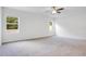 This bedroom features carpeted floor, white walls, ceiling fan and large windows offering natural light at 3504 Kearsney Abbey Cir, Dover, FL 33527