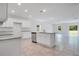 Open kitchen design with white cabinetry, granite countertops, and a center island with a sink at 3504 Kearsney Abbey Cir, Dover, FL 33527