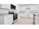 Modern kitchen featuring stainless steel appliances, granite countertops, and white cabinets at 3504 Kearsney Abbey Cir, Dover, FL 33527
