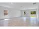 Bright living room with tile flooring, large windows, and sliding door access to the backyard at 3504 Kearsney Abbey Cir, Dover, FL 33527