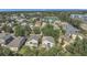 Neighborhood aerial shot shows tree-lined streets, well-kept lawns, and a calm lake at 4432 Huddlestone Dr, Wesley Chapel, FL 33545