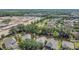 Aerial view showing a residential neighborhood with ponds, tree cover, and nearby construction at 4432 Huddlestone Dr, Wesley Chapel, FL 33545