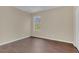 A bright bedroom featuring modern brown floors and a window offering an outdoor view at 4432 Huddlestone Dr, Wesley Chapel, FL 33545