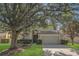 Charming two-story home with a well-manicured lawn, mature trees, and a two-car garage at 4432 Huddlestone Dr, Wesley Chapel, FL 33545