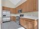 Well-lit kitchen featuring stainless steel appliances, light countertops and hardwood cabinets at 4432 Huddlestone Dr, Wesley Chapel, FL 33545