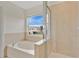 Bathroom with a white tub and shower combo, tiled walls, and natural lighting at 4722 67Th N Ave, Pinellas Park, FL 33781