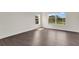 Sunlit room with wood-style floors and large windows offer inviting view of green space at 4722 67Th N Ave, Pinellas Park, FL 33781