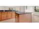 Open kitchen with an island, stainless steel dishwasher, and wood cabinets with dark countertops at 4722 67Th N Ave, Pinellas Park, FL 33781