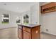 Bright kitchen island with counter seating, offering views of the backyard, and featuring wood cabinets and a wine rack at 4722 67Th N Ave, Pinellas Park, FL 33781