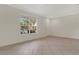 Bright living room with neutral tile flooring and a large window offering a pleasant outdoor view at 4722 67Th N Ave, Pinellas Park, FL 33781