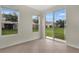 Sunlit living area with tiled flooring, two windows, and a sliding glass door leading to the backyard at 4722 67Th N Ave, Pinellas Park, FL 33781