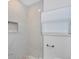 An updated bathroom with white marbled tile, a built-in shower niche, and modern finishes at 7824 Starkey Rd, Seminole, FL 33777
