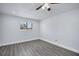 Simple bedroom with hard surface floor, natural light from the window, and ceiling fan at 7824 Starkey Rd, Seminole, FL 33777