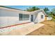 Charming single-story home with white exterior, modern windows, tidy landscaping and a walkway to the front door at 7824 Starkey Rd, Seminole, FL 33777