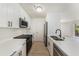 Modern white kitchen featuring stainless steel appliances, quartz countertops, and laminate floors at 11901 4Th N St # 2107, St Petersburg, FL 33716
