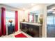 Bathroom features a double sink vanity with granite countertop, decorative plants and mirrors, and bright window at 11910 Field Thistle Ct, Riverview, FL 33579
