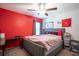 Modern bedroom with a gray upholstered bed and a striking red accent wall at 11910 Field Thistle Ct, Riverview, FL 33579