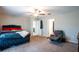 Spacious bedroom includes a ceiling fan, comfortable recliner, and access to an ensuite bathroom at 11910 Field Thistle Ct, Riverview, FL 33579