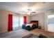 Bedroom with a black headboard, neutral walls, ceiling fan and red accents at 11910 Field Thistle Ct, Riverview, FL 33579