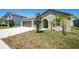 Inviting single-story home featuring a well-kept lawn and an arched entryway at 11910 Field Thistle Ct, Riverview, FL 33579