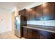 Kitchen area showcasing stainless steel refrigerator, dark cabinets, and granite countertops at 11910 Field Thistle Ct, Riverview, FL 33579