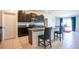 Kitchen featuring dark cabinets, stainless steel appliances, granite countertops, island with bar stool seating and tile floors at 11910 Field Thistle Ct, Riverview, FL 33579