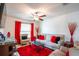 Bright living room with a ceiling fan, comfortable seating, area rug and window with red curtains for a touch of color at 11910 Field Thistle Ct, Riverview, FL 33579