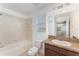 Bright bathroom featuring a bathtub, toilet, and granite countertop vanity at 13188 Royal Pines Ave, Riverview, FL 33579