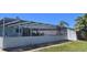 Spacious, fenced-in yard with screen enclosure and outdoor seating area at 3309 Rock Valley Dr, Holiday, FL 34691