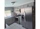 Well-lit kitchen with stainless steel appliances, gray cabinets, and a view of the outdoor pool at 3309 Rock Valley Dr, Holiday, FL 34691