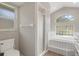 Bathroom featuring arched window, shower and tub at 621 Erin Way, Brooksville, FL 34601