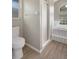 Bright bathroom features a white toilet, shower, and a tiled bathtub with glass-block window at 621 Erin Way, Brooksville, FL 34601