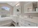 Bathroom featuring double sink vanity, glass block window and bath at 621 Erin Way, Brooksville, FL 34601